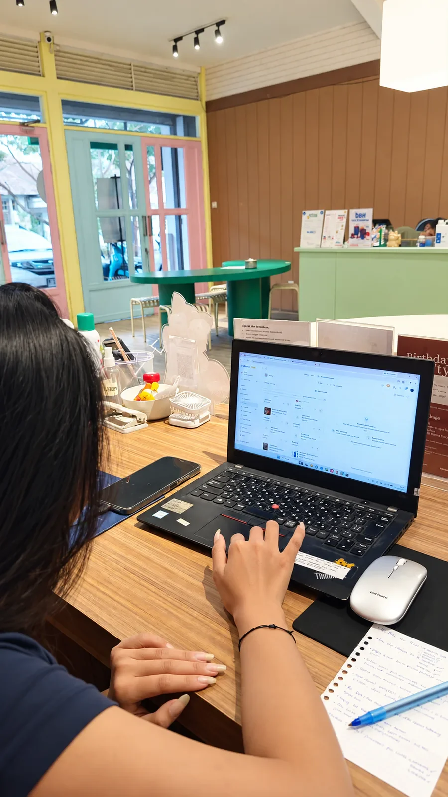 Staf Woofbar menggunakan PAWSI untuk mengelola inventori petshop di laptop.